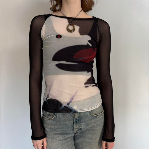 Front view of black sheer mesh graphic top for women with long sleeves, fitted stretchy Y2K going out top, abstract print cool girl blouse, trendy boutique fashion shirt paired with denim jeans, sheer streetwear top.
