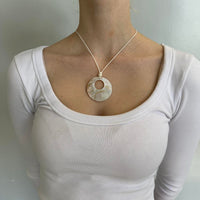 Mother of pearl pendant necklace with iridescent shell circle charm on a minimalist cord chain, styled with a clean girl white ribbed top. Coastal chic Y2K jewelry perfect for beachy outfits, Pinterest fashion inspiration, and trendy minimalist everyday wear.