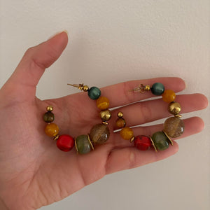 Colorful chunky beaded hoop earrings featuring multicolor resin-style beads with gold accents in a bold retro-inspired design. Trendy Y2K statement earrings with eclectic coastal cool girl aesthetic, perfect for Pinterest fashion, vacation outfits, artsy jewelry styling, and playful IT girl accessories.