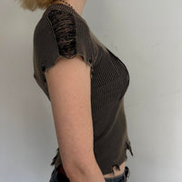 Side view of distressed ribbed baby tee in washed brown featuring frayed sleeve detailing, stretchy fitted knit fabric, and edgy Y2K grunge aesthetic. Vintage-inspired indie sleaze women’s top with raw hem accents and flattering body-hugging fit.