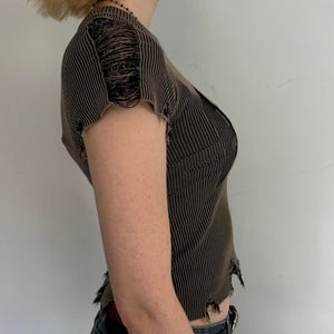Side view of distressed ribbed baby tee in washed brown featuring frayed sleeve detailing, stretchy fitted knit fabric, and edgy Y2K grunge aesthetic. Vintage-inspired indie sleaze women’s top with raw hem accents and flattering body-hugging fit.