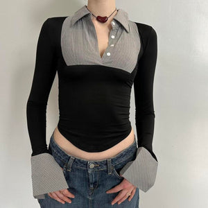 Front view of black and grey office siren contrast collared top for women with long sleeves, fitted stretchy Y2K going out top, corporate chic blouse with pointed hem and oversized cuffs, trendy boutique fashion top paired with low rise denim skirt.