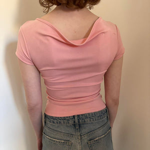 Back view of pink fitted baby tee top for women, stretchy Y2K crop top aesthetic, slim fit short sleeve pastel pink shirt, trendy coquette style casual top paired with low rise denim jeans, minimal boutique fashion look.