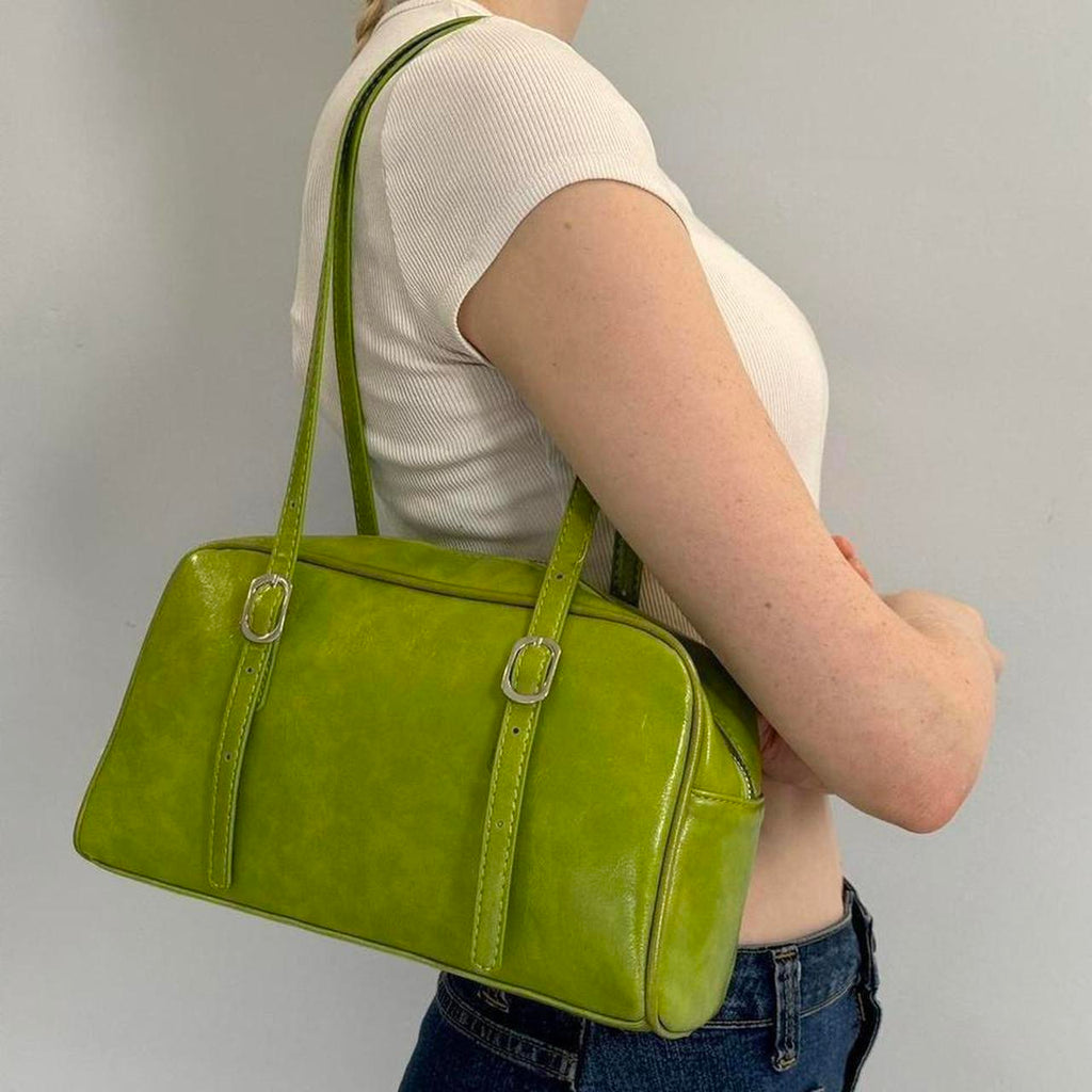 Lime green Y2K shoulder bag, glossy baguette purse with adjustable buckle straps, trendy 2000s aesthetic handbag styled with white ribbed tee and denim jeans, statement street style accessory for women