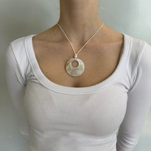 Mother of pearl pendant necklace with iridescent shell circle charm on a minimalist cord chain, styled with a clean girl white ribbed top. Coastal chic Y2K jewelry perfect for beachy outfits, Pinterest fashion inspiration, and trendy minimalist everyday wear.