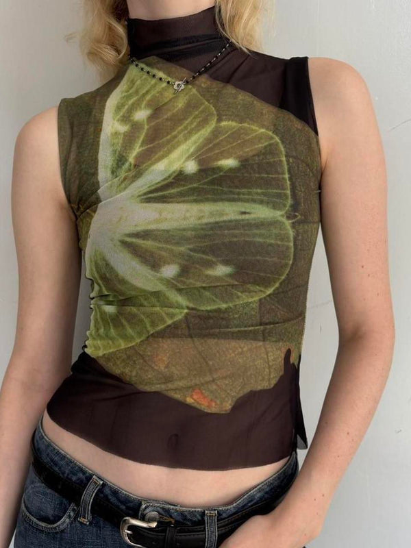 Model wearing lime slice mesh asymmetrical top with sheer black mock neck design, Y2K graphic sleeveless tank top, trendy women’s going out top paired with low rise jeans.