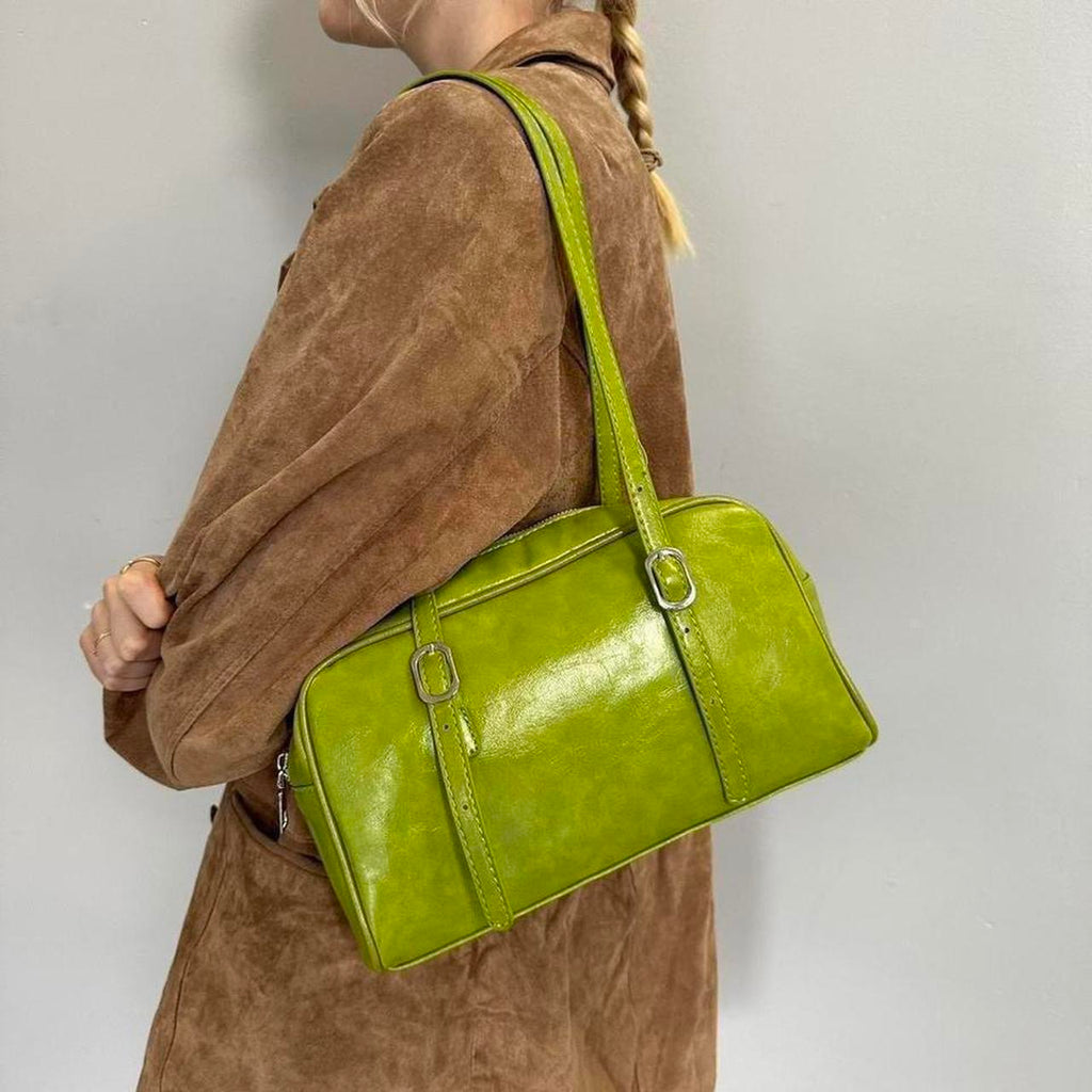 Lime green Y2K shoulder bag, glossy baguette handbag with adjustable buckle straps, vintage-inspired mini purse styled with brown suede jacket, trendy 2000s aesthetic accessory, statement street style bag for women