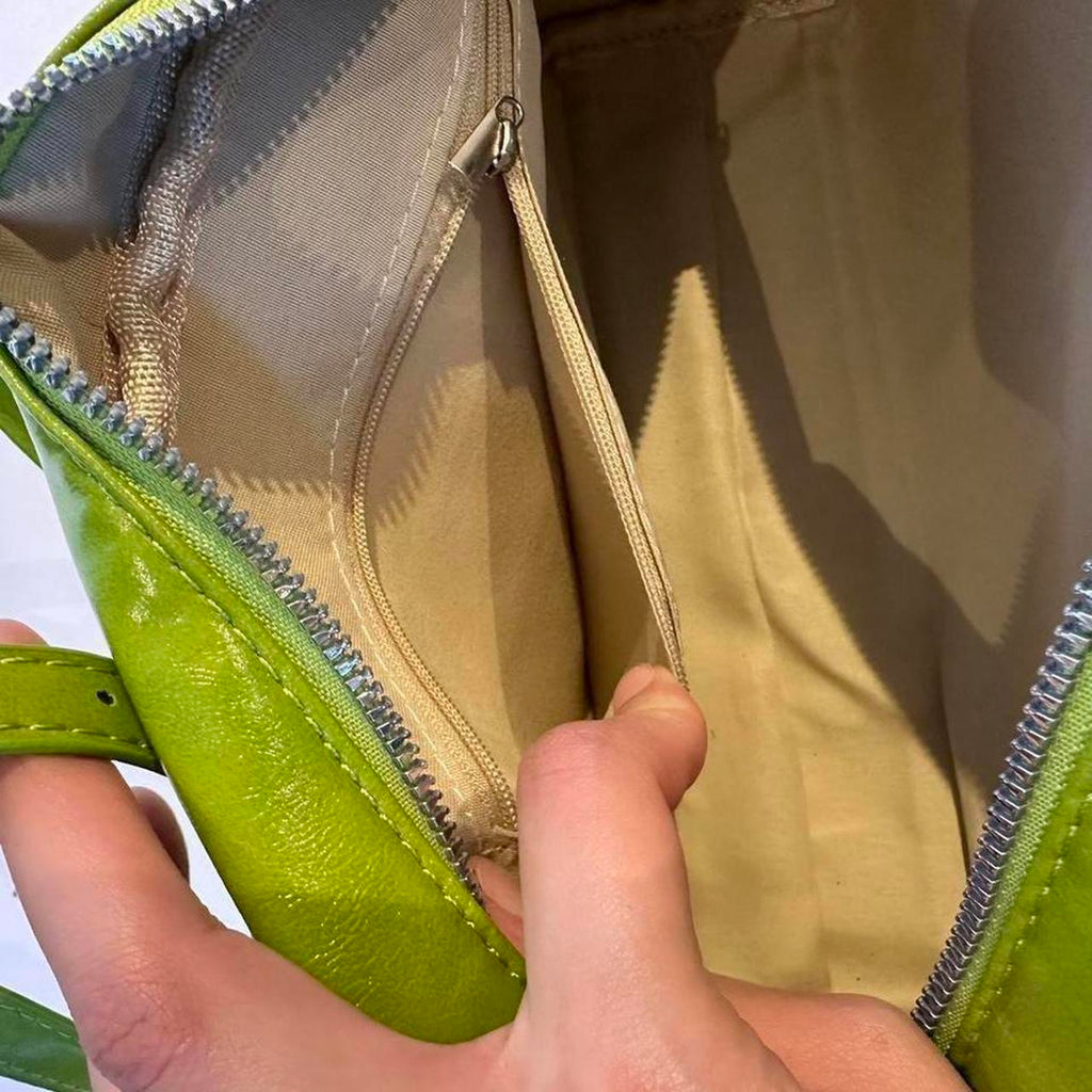 Lime green Y2K shoulder bag interior close-up, glossy faux leather mini baguette purse with zipper closure and inner zip pocket, beige lining detail, vintage-inspired 2000s handbag, functional trendy aesthetic accessory for everyday use