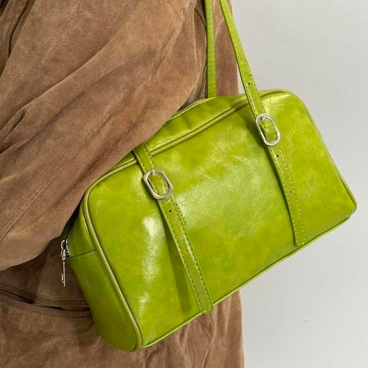 Lime green Y2K shoulder bag close-up, glossy faux leather baguette purse with adjustable buckle straps, vintage-inspired 2000s handbag detail, trendy retro aesthetic accessory, statement mini shoulder bag for women