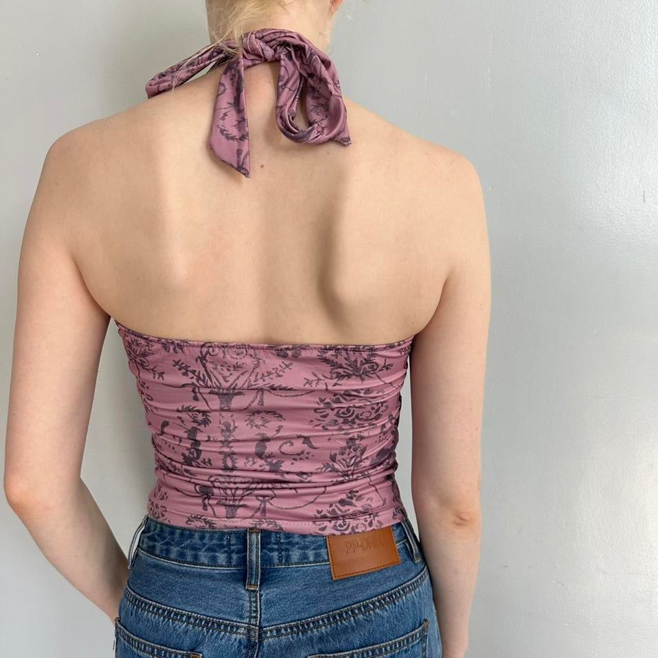 Back view of pink floral halter top with adjustable tie-neck design and vintage-inspired print, styled with blue denim jeans. Stretchy Y2K aesthetic backless tank top featuring soft girl, coquette, and fairycore fashion vibes. Feminine polyester summer top with fitted silhouette, perfect for trendy streetwear outfits, Pinterest fashion inspiration, and going out looks.