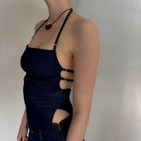 Side view of navy blue Y2K halter top with side cut-outs and adjustable straps, fitted backless tank top on model, minimalist aesthetic going out top, stretchy bodycon halter top paired with denim mini skirt, trendy 2000s inspired women’s fashion outfit