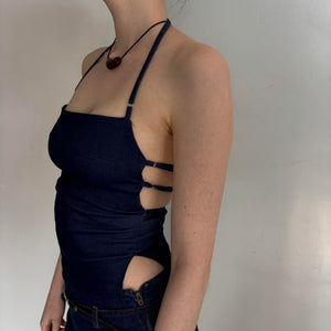 Side view of navy blue Y2K halter top with side cut-outs and adjustable straps, fitted backless tank top on model, minimalist aesthetic going out top, stretchy bodycon halter top paired with denim mini skirt, trendy 2000s inspired women’s fashion outfit