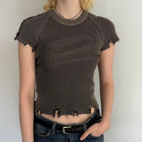 Distressed ribbed baby tee in washed brown featuring a fitted stretchy knit design, raw frayed hems, and vintage-inspired Y2K grunge aesthetic. Trendy indie sleaze women’s top styled with low rise jeans for a cool girl Pinterest outfit.