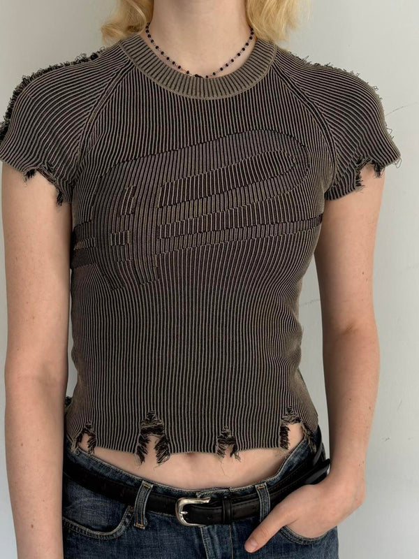 Distressed ribbed baby tee in washed brown featuring a fitted stretchy knit design, raw frayed hems, and vintage-inspired Y2K grunge aesthetic. Trendy indie sleaze women’s top styled with low rise jeans for a cool girl Pinterest outfit.
