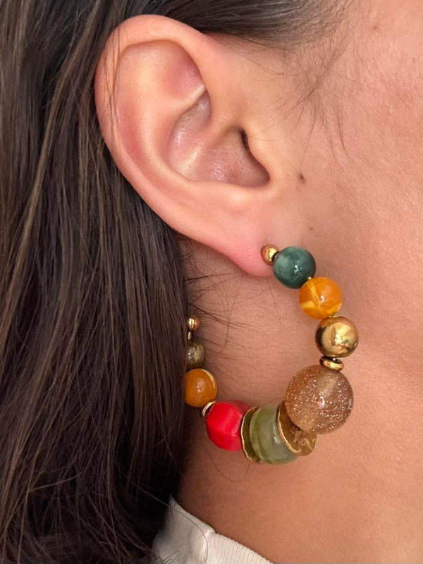 Colorful beaded hoop earrings featuring chunky multicolor resin beads and gold accents in a bold retro-inspired design. Trendy Y2K statement earrings with coastal cool girl aesthetic, perfect for Pinterest fashion, vacation outfits, eclectic jewelry styling, and artsy IT girl looks.